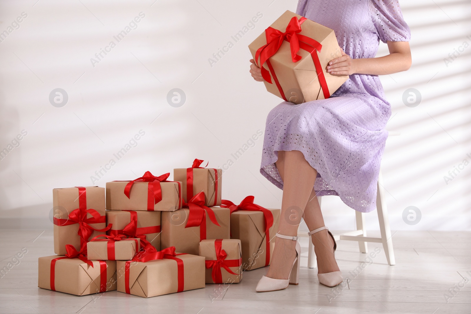 Photo of Woman with gift boxes sitting on stool, closeup. Black Friday