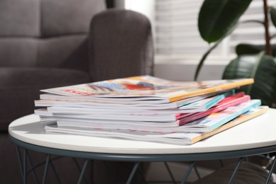 Many stacked magazines on table in room