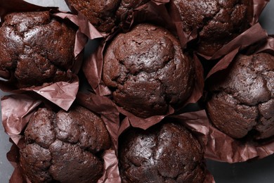 Tasty chocolate muffins on black table, top view