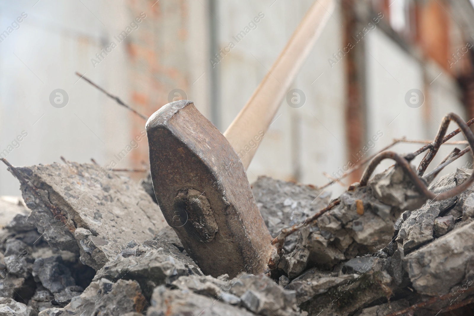 Photo of Sledgehammer on pile of broken stones outdoors, closeup