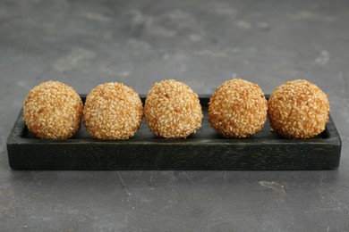Photo of Many delicious sesame balls on grey table