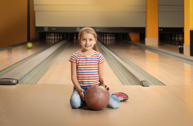 Photo of Little girl with ball in bowling club