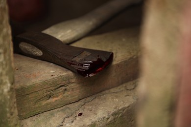 Photo of Axe with blood on wooden threshold, closeup