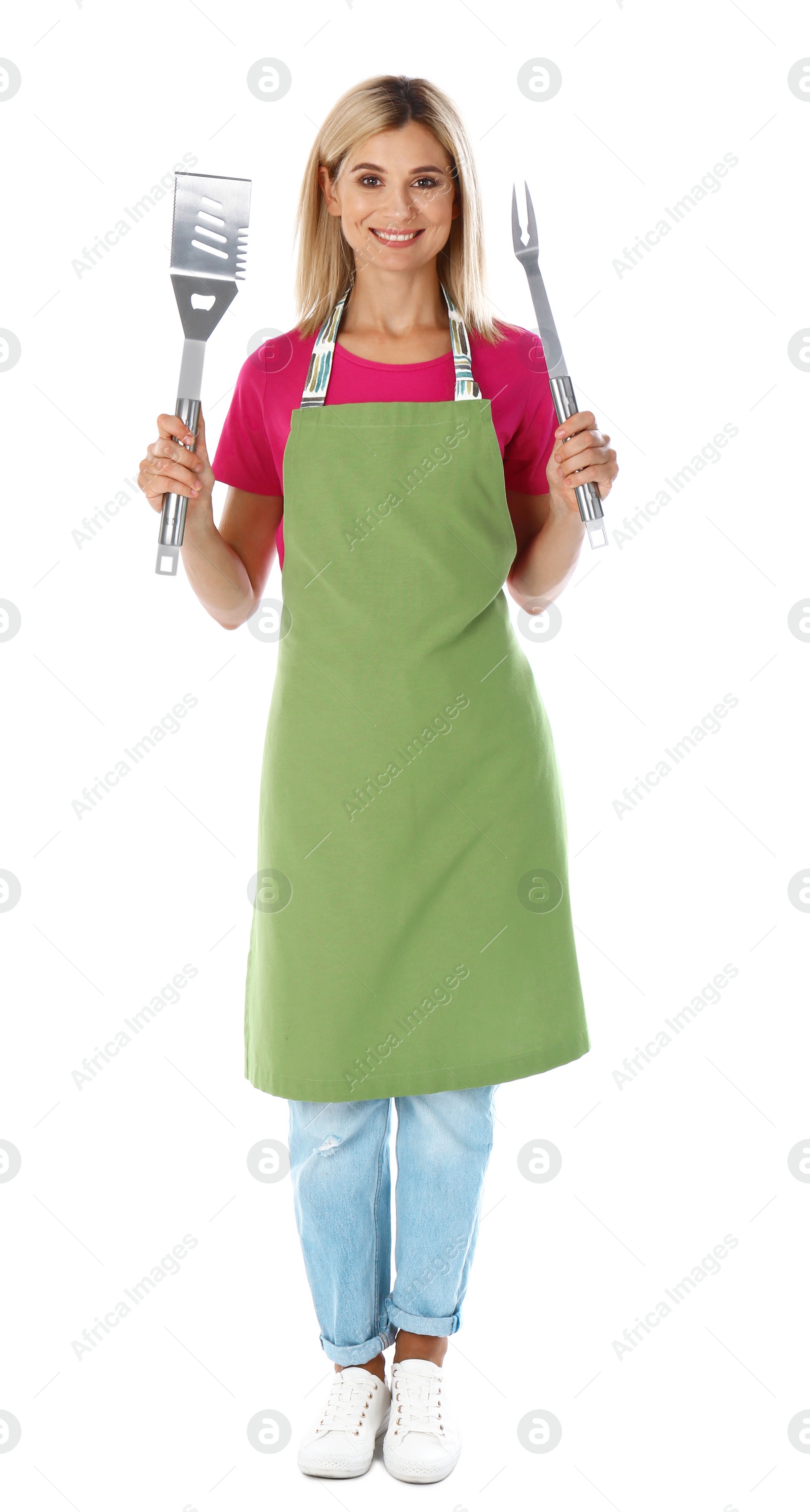 Photo of Woman in apron with barbecue utensils on white background