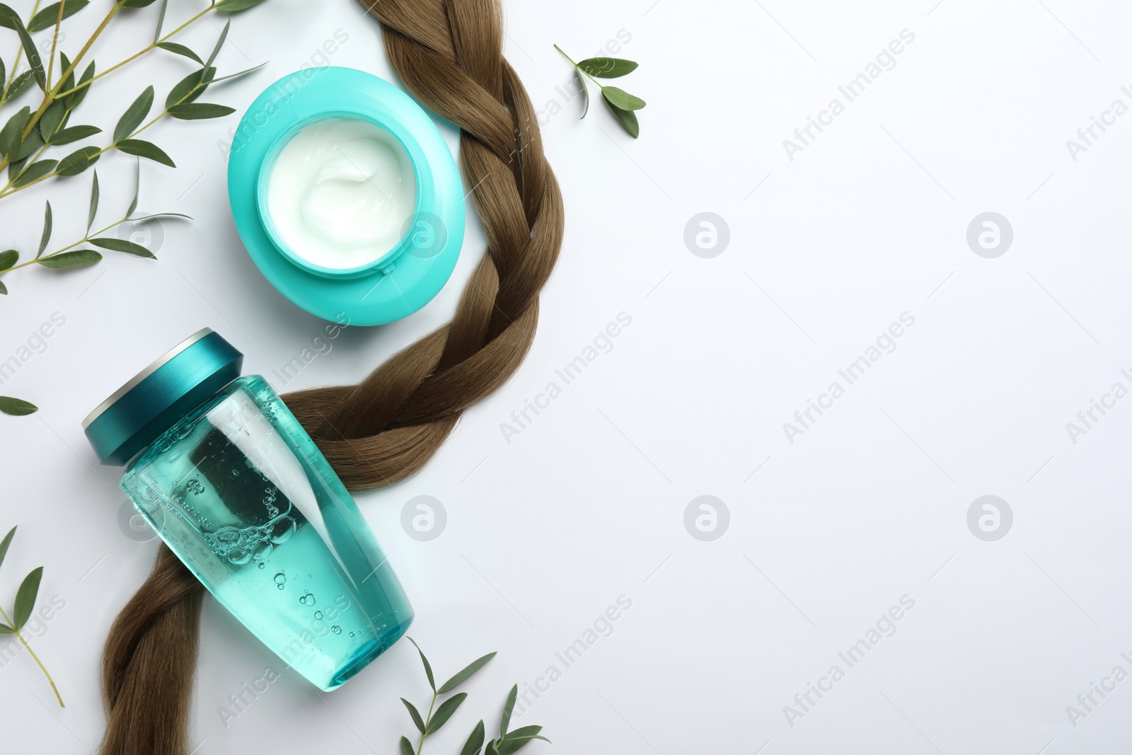 Photo of Natural cosmetic products, green leaves and hair braid on white background, flat lay. Space for text