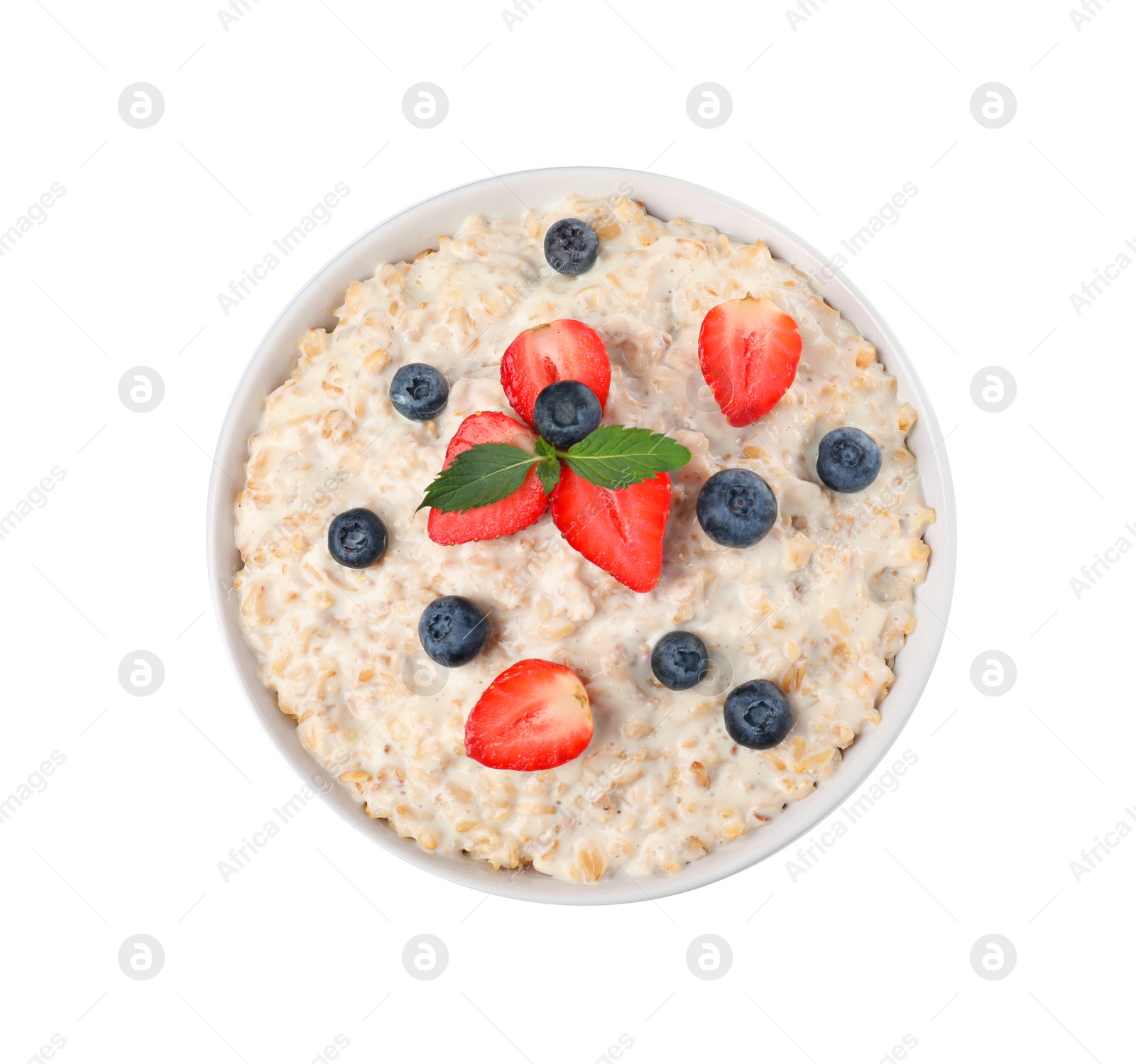 Photo of Tasty boiled oatmeal with berries in bowl isolated on white, top view