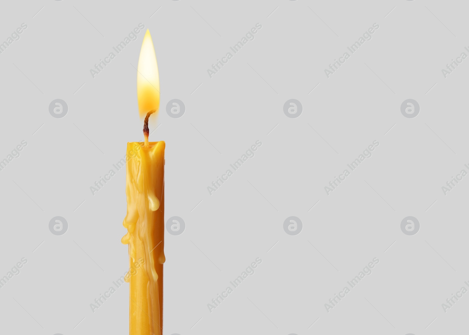 Image of Burning church candle on light background. Space for text