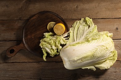 Fresh Chinese cabbage and lemon on wooden table, flat lay