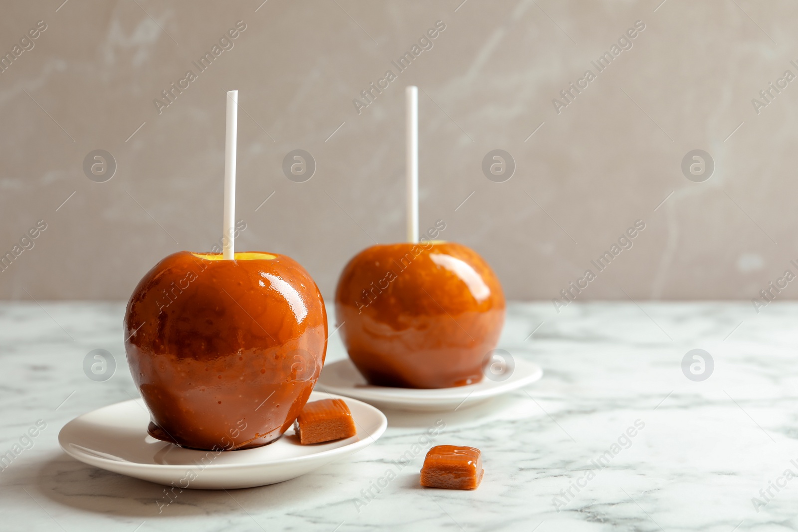 Photo of Delicious green caramel apples on marble table