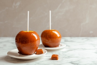 Photo of Delicious green caramel apples on marble table