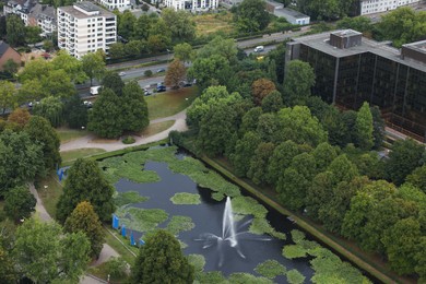 Photo of View of beautiful city with buildings, trees and fountain