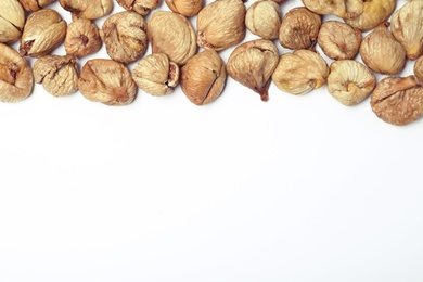 Photo of Dried figs on white background, top view with space for text. Healthy fruit