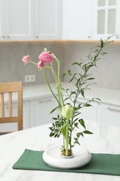 Ikebana art. Beautiful pink flowers and green branch carrying cozy atmosphere at home