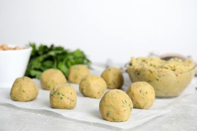 Photo of Raw falafel balls on grey table, space for text