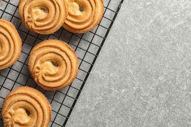 Baking grid with Danish butter cookies on grey table, top view. Space for text