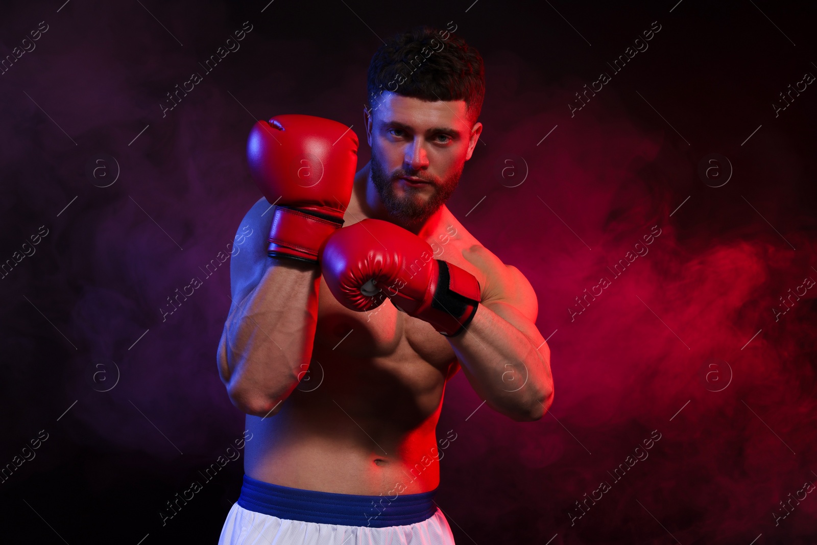 Photo of Man wearing boxing gloves on dark background