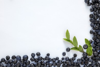 Ripe bilberries and sprig on white background, flat lay. Space for text