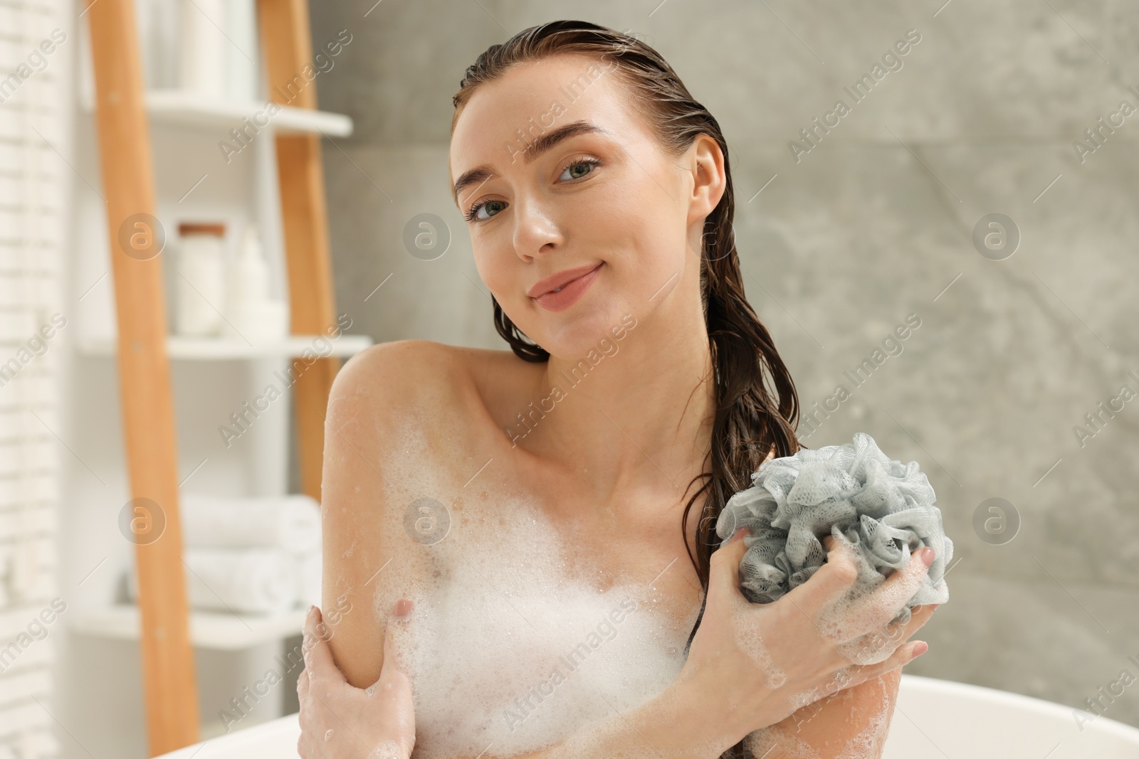 Photo of Woman taking bath with shower gel in bathroom