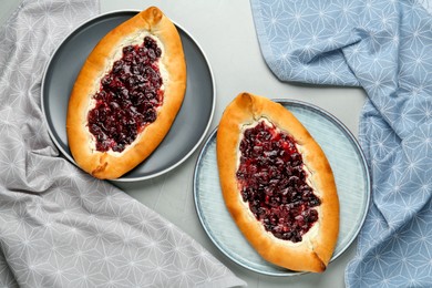 Delicious sweet cottage cheese pastries with cherry jam on grey table, flat lay