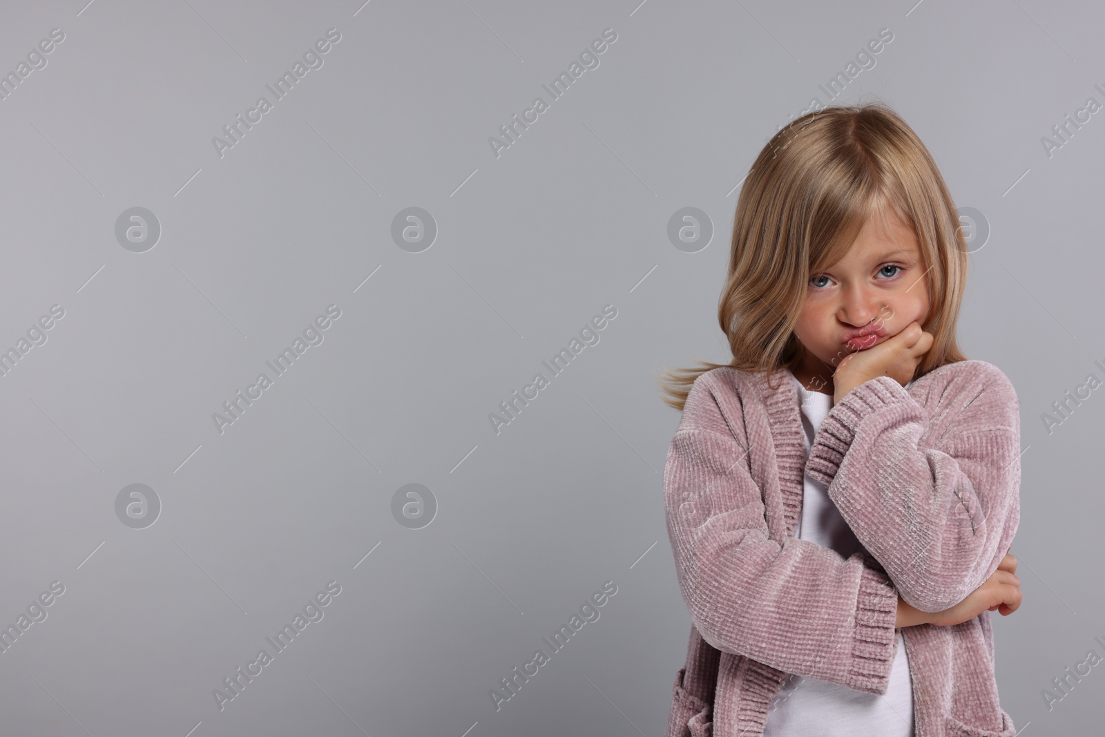 Photo of Resentful girl on grey background. Space for text