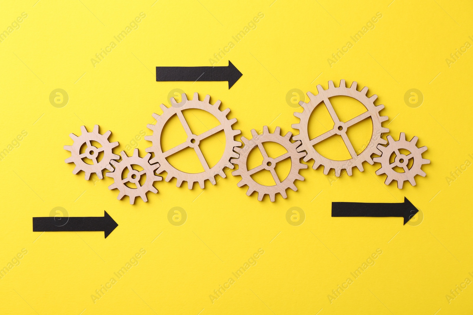 Photo of Business process organization and optimization. Scheme with wooden figures and arrows on yellow background, top view