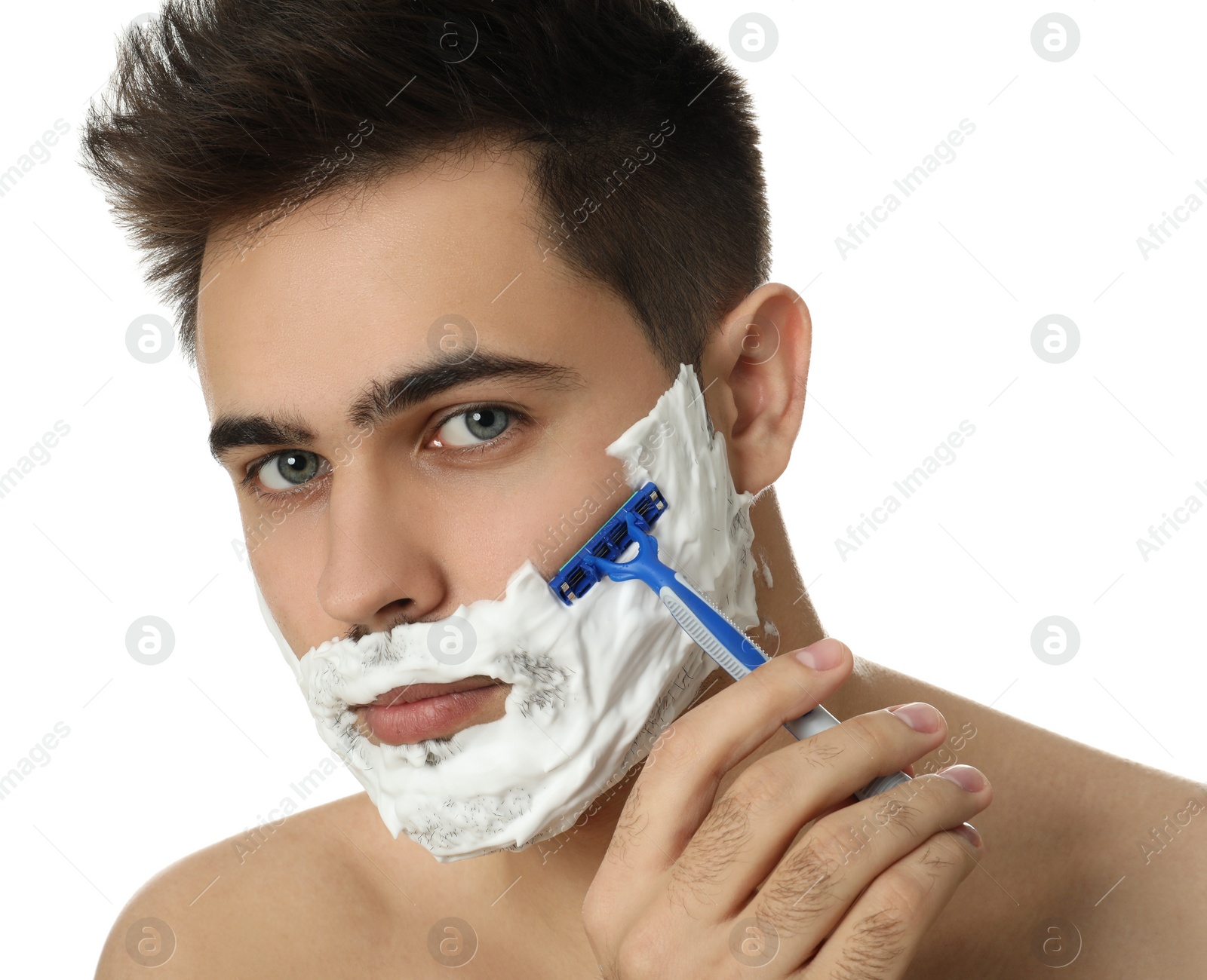 Photo of Handsome young man shaving with razor on white background