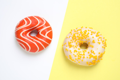 Delicious glazed donuts on color background, flat lay