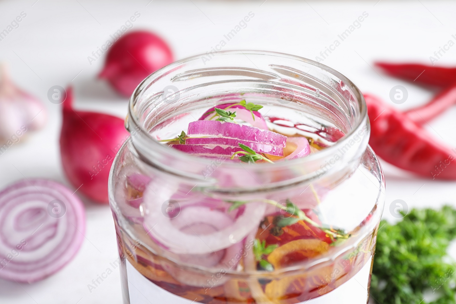 Photo of Jar of pickled onions on table, closeup