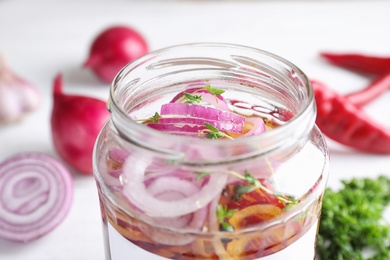 Jar of pickled onions on table, closeup