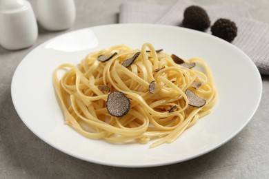 Photo of Tasty fettuccine with truffle on light grey table