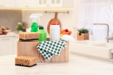 Different cleaning supplies on table in kitchen. Space for text