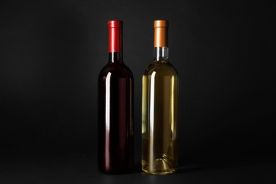 Bottles of expensive red and white wines on dark background