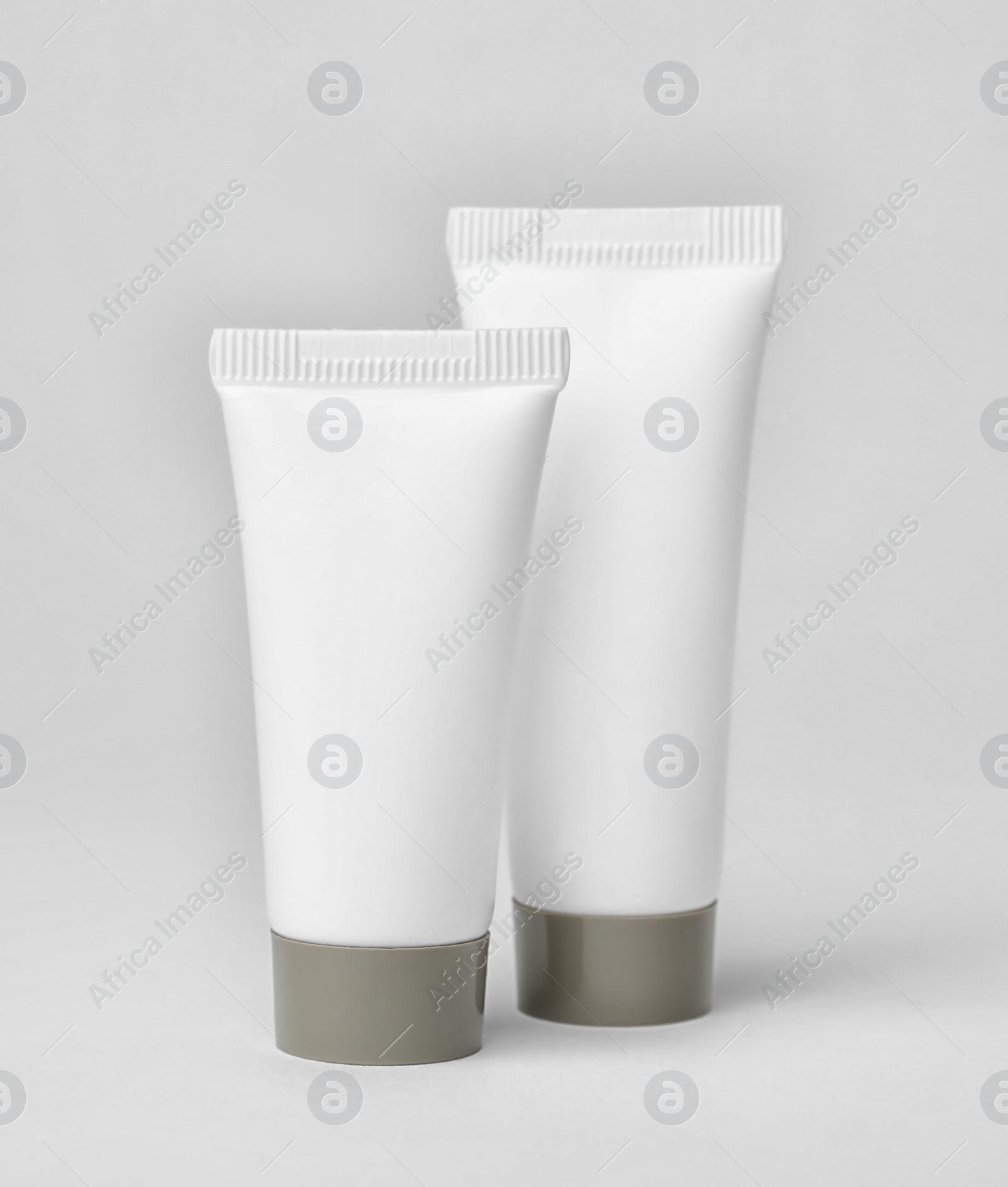Photo of Tubes of cosmetic products on light background