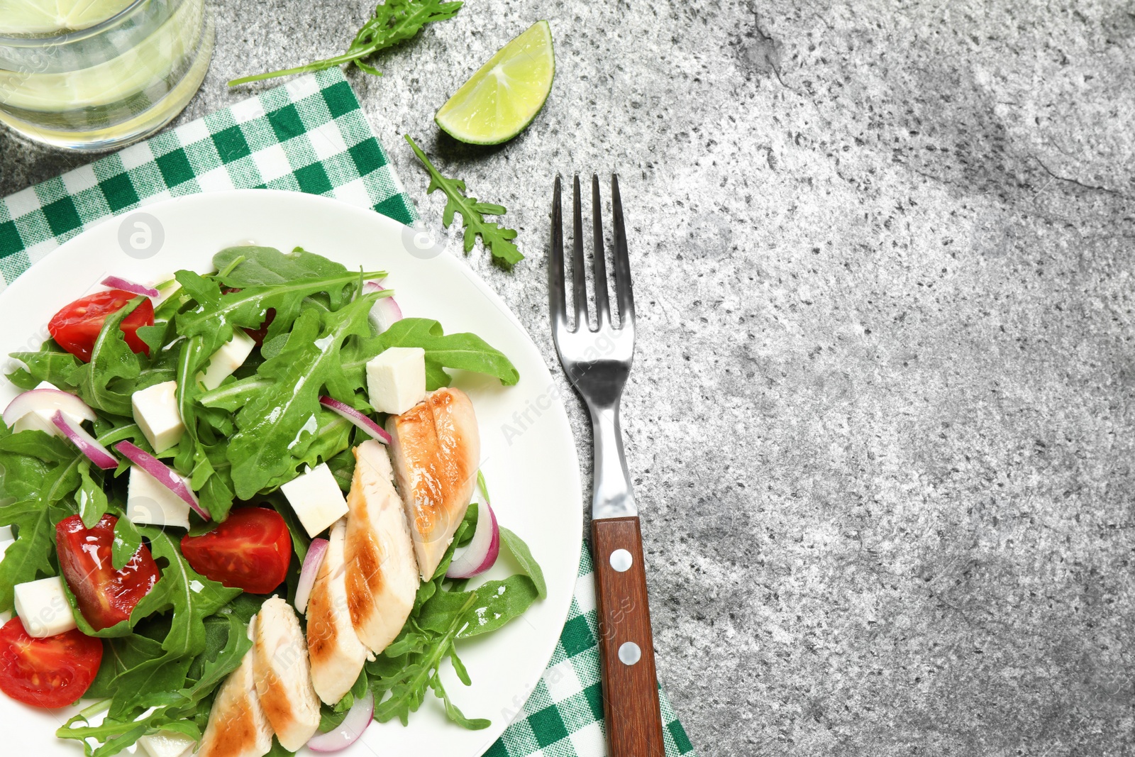 Photo of Delicious salad with meat, arugula and vegetables on grey table, flat lay. Space for text