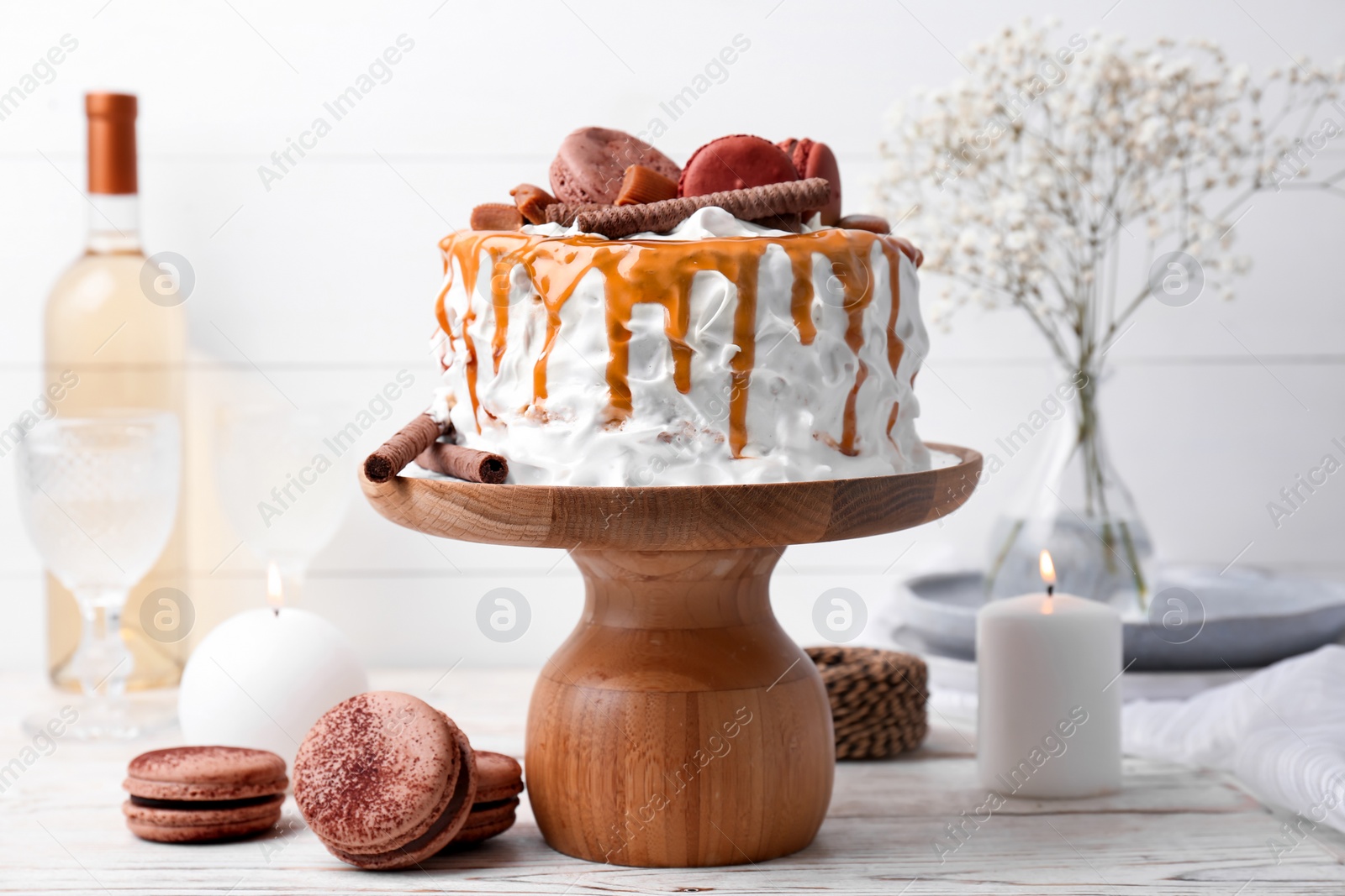 Photo of Delicious homemade cake with caramel sauce and cookies on table