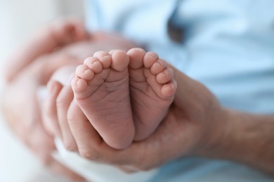 Photo of Father holding his newborn baby at home, closeup. Space for text