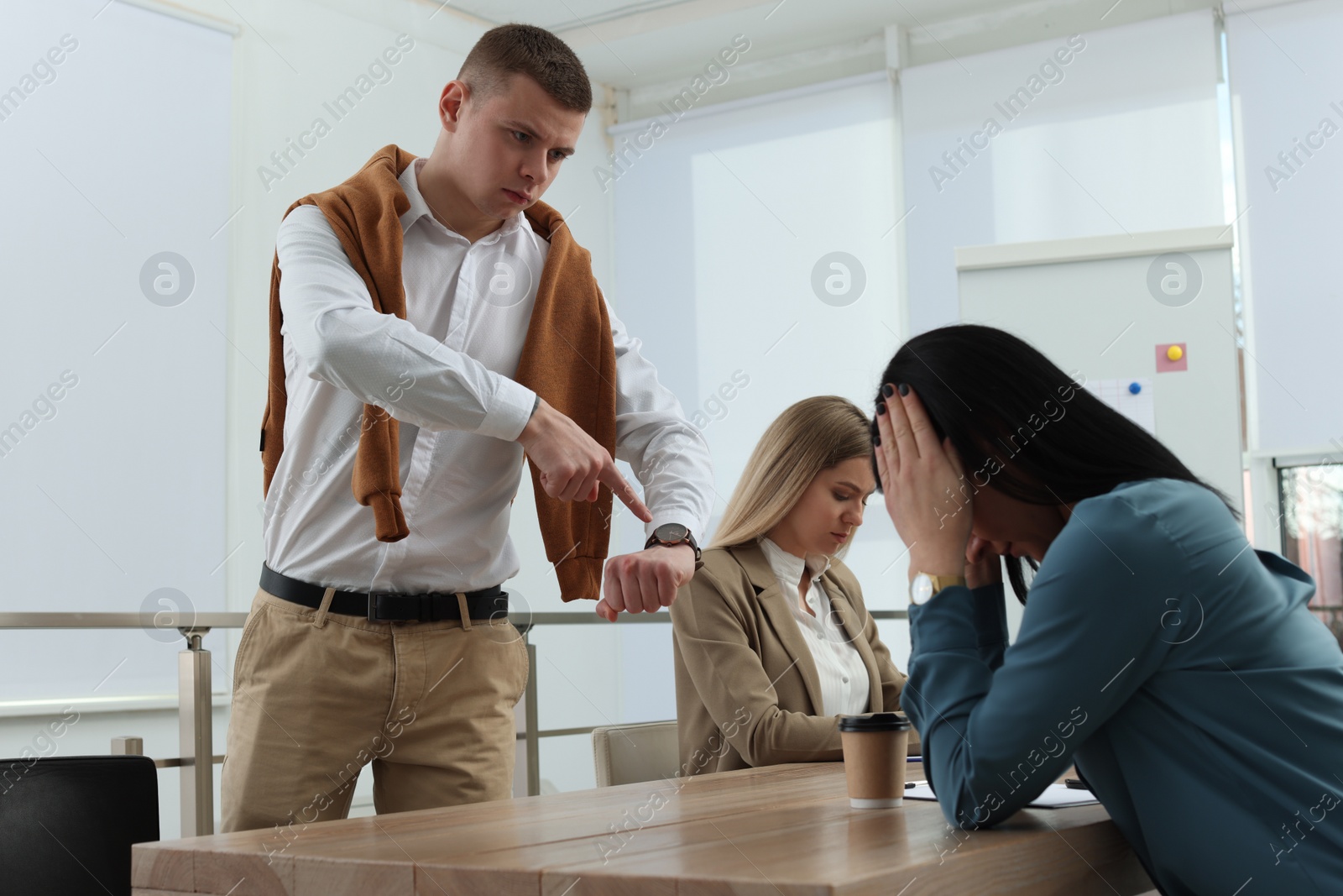 Photo of Businessman scolding employee for being late on meeting in office