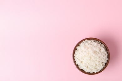 Photo of Bowl of boiled rice on color background, top view with space for text