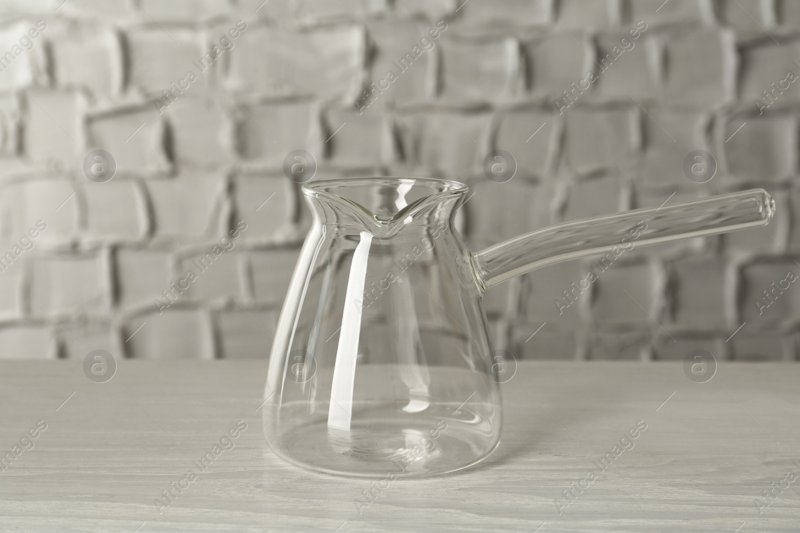 Photo of Glass turkish coffee pot on white wooden table