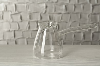 Glass turkish coffee pot on white wooden table