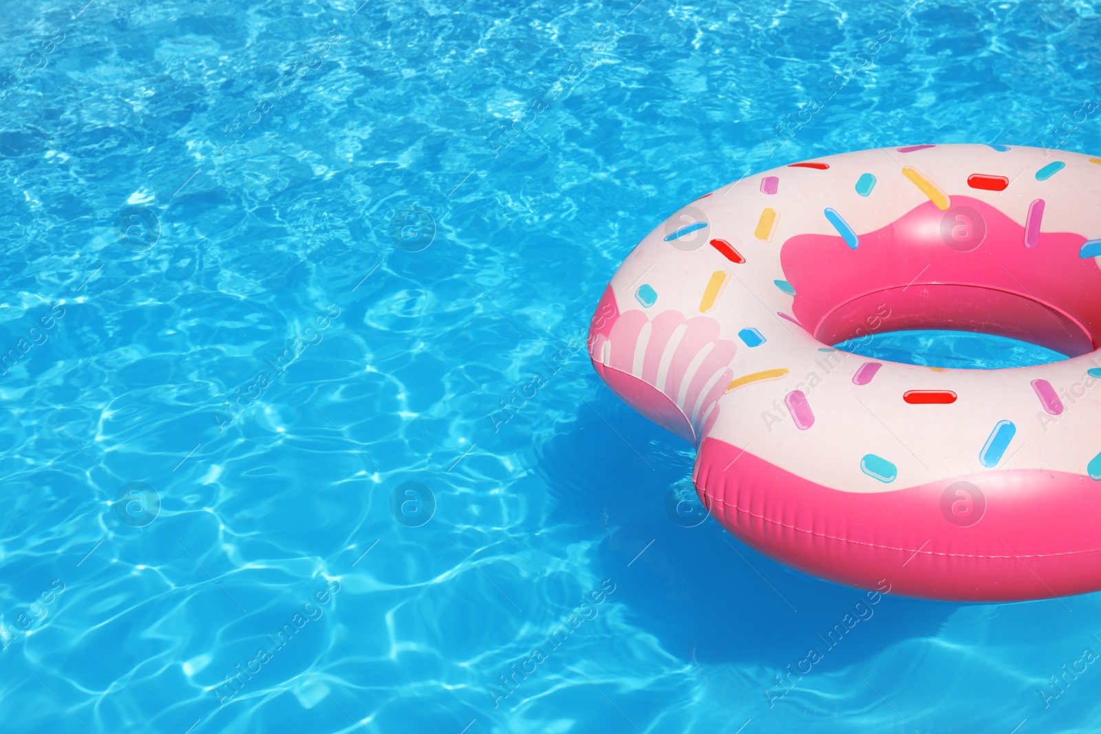 Photo of Inflatable ring floating in swimming pool on sunny day. Space for text