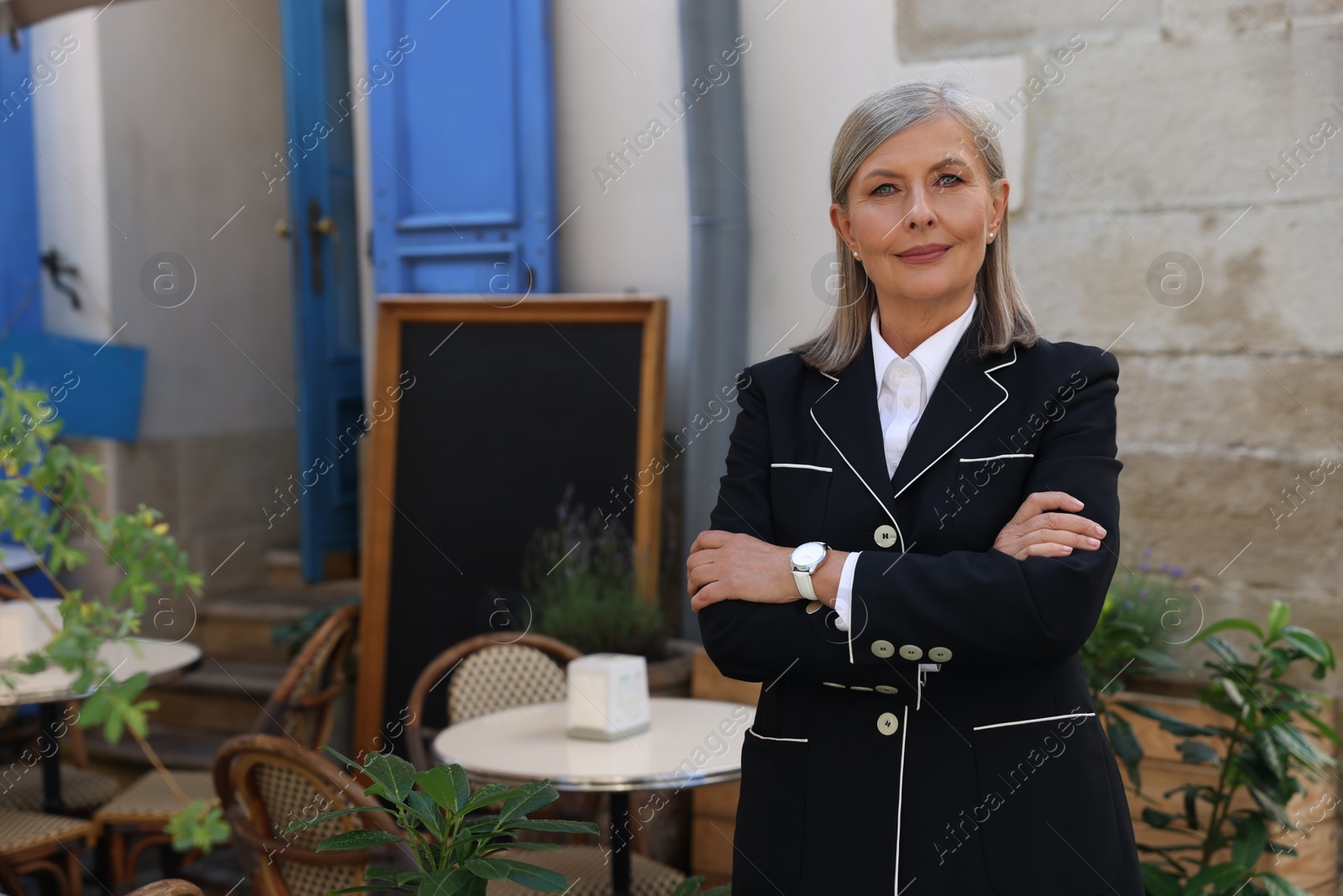 Photo of Beautiful business owner near her cafe outdoors, space for text