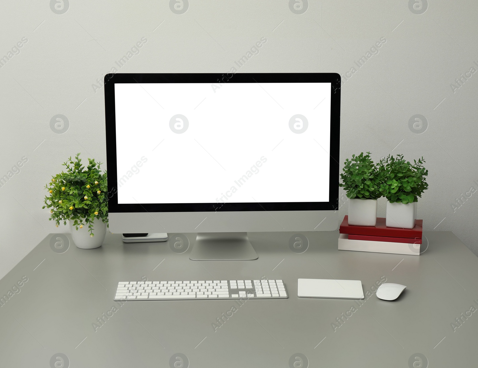 Photo of Modern workplace with computer and houseplants. Interior design