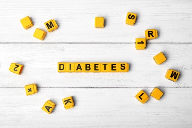 Photo of Flat lay composition with word DIABETES on wooden background