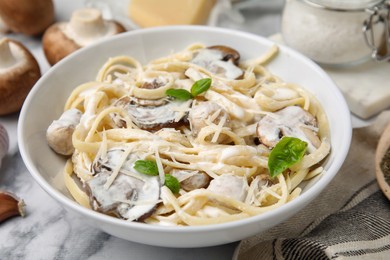 Photo of Delicious pasta with mushrooms on white marble table, closeup