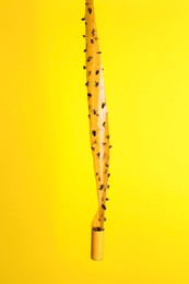 Photo of Sticky insect tape with dead flies on yellow background