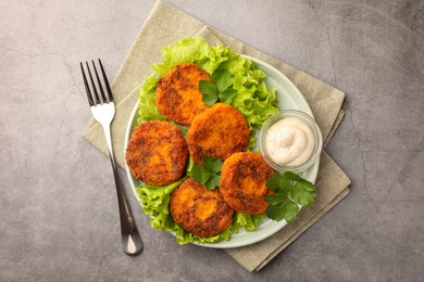 Photo of Tasty vegan cutlets served with sauce on light grey table, top view