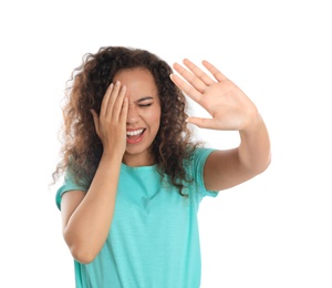 Young African-American woman being blinded on white background