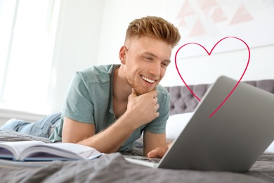 Image of Young man visiting dating site via laptop indoors
