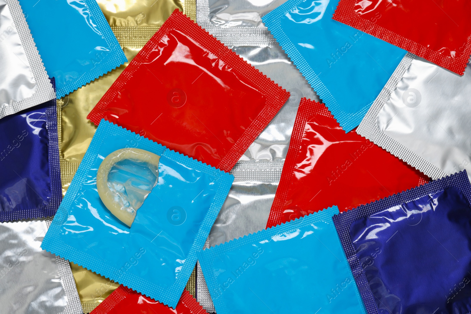 Photo of Packaged condoms as background, top view. Safe sex